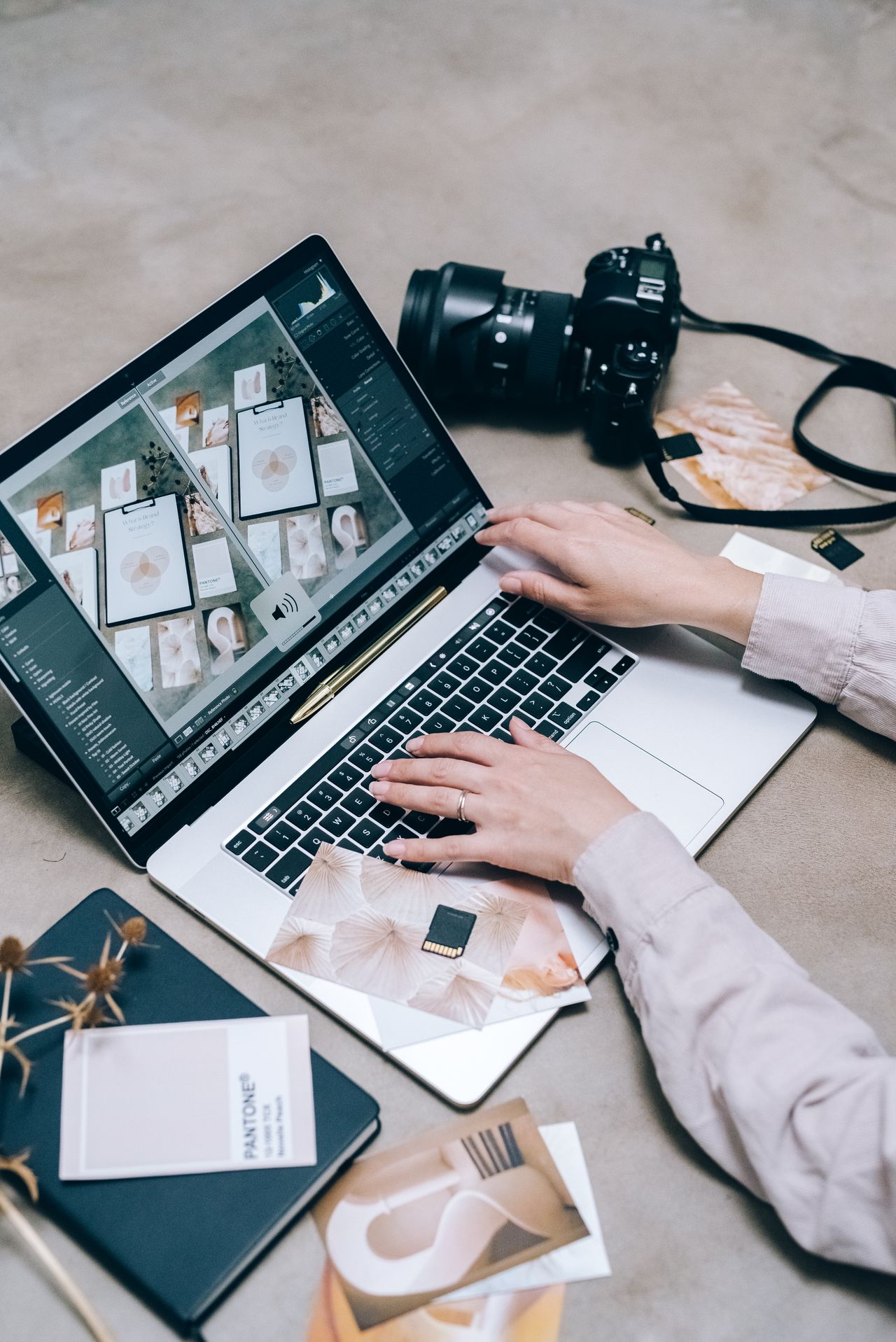 Photo editing on a laptop beside a camera