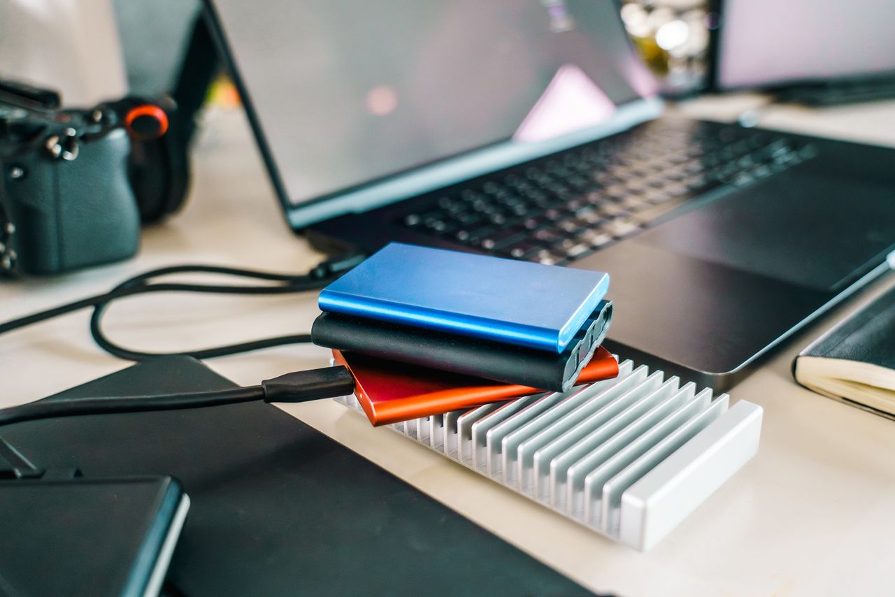 External drives and camera beside a laptop