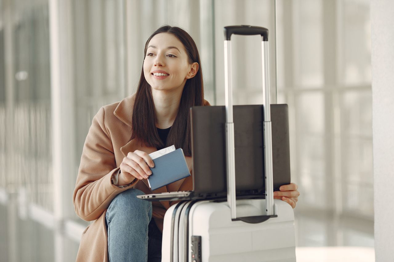 Reisende mit Pass und Laptop am Flughafen
